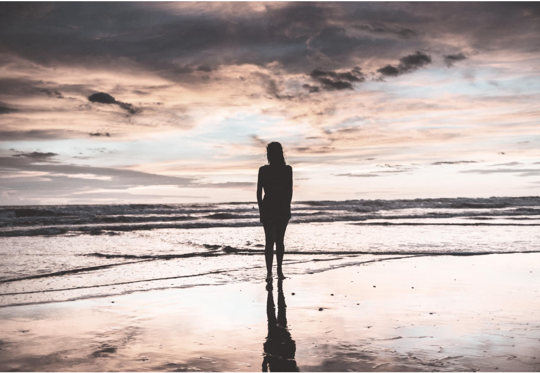 Silhouette of a person at the ocean practicing somatic awareness and nervous system regulation through embodied posture reflection